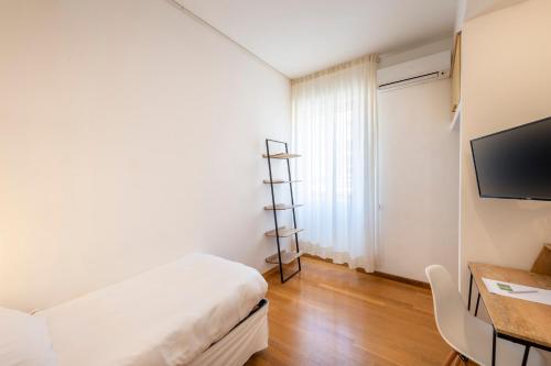 a bedroom with a bed and a desk and a television at Hotel San Michele in Celle Ligure