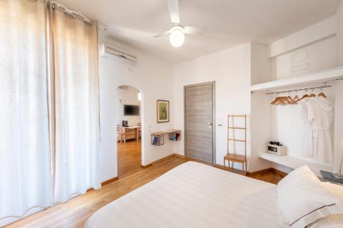 a white bedroom with a bed and a window at Hotel San Michele in Celle Ligure