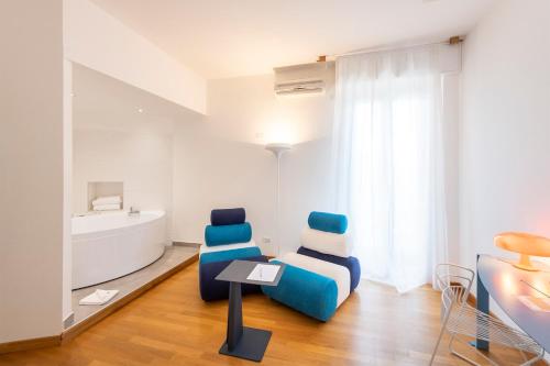 a living room with a blue chair and a table at Hotel San Michele in Celle Ligure
