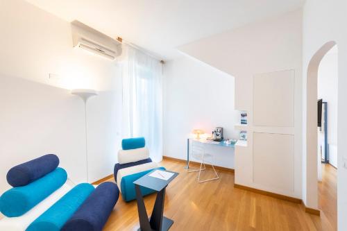 a living room with a blue couch and a chair at Hotel San Michele in Celle Ligure