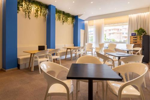 a dining room with tables and white chairs at Best Western Hotel Matisse in Sainte-Maxime
