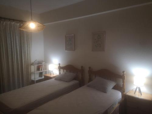 two beds in a bedroom with two lights on at Dreaming of Algarve in Porches