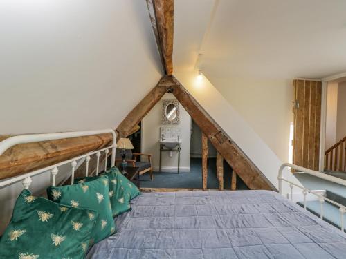a attic bedroom with a bed and a staircase at 9 Velley Hill in Corsham