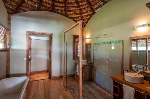 a bathroom with a shower and a sink and a toilet at Massinga Beach in Massinga