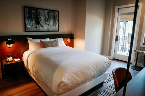 a bedroom with a large white bed and a window at Gateway Hotel, Trademark Collection by Wyndham in Copper Cove Subdivision
