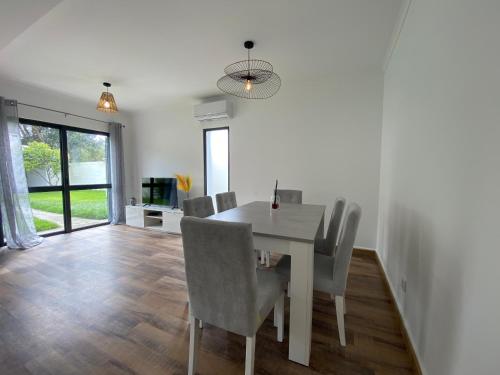 ein Esszimmer mit einem weißen Tisch und Stühlen in der Unterkunft Casa da Estrela in Ribeira Grande