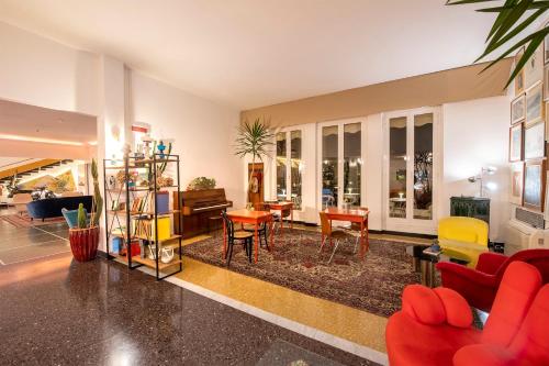 a living room with a red couch and chairs at Hotel San Michele in Celle Ligure