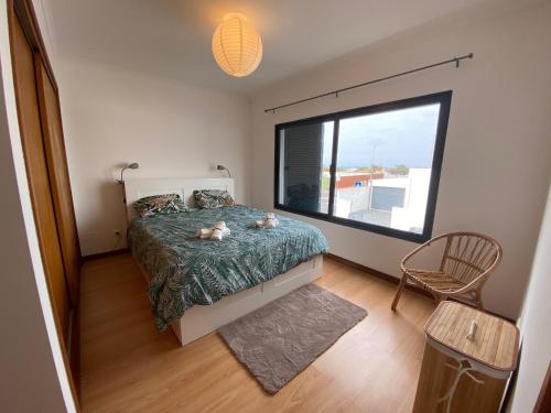 a bedroom with a bed and a large window at Casa da Estrela in Ribeira Grande