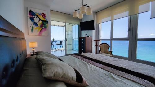 sypialnia z dużym łóżkiem i widokiem na ocean w obiekcie BAUPRES luxury apartment w mieście Calpe