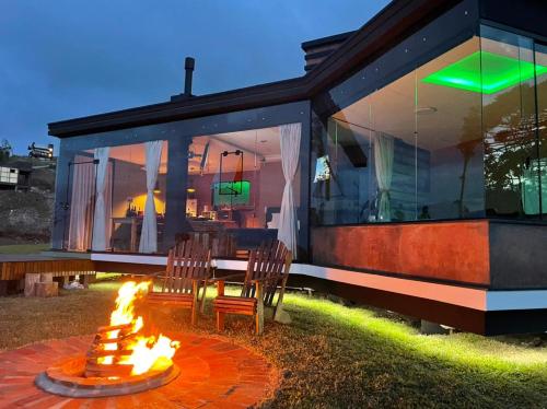 a fire pit in front of a house at Caminho das Nuvens - Cabanas de Montanha in Bom Retiro