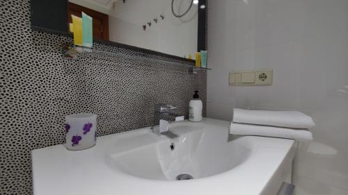 W białej łazience znajduje się umywalka i lustro. w obiekcie BAUPRES luxury apartment w mieście Calpe