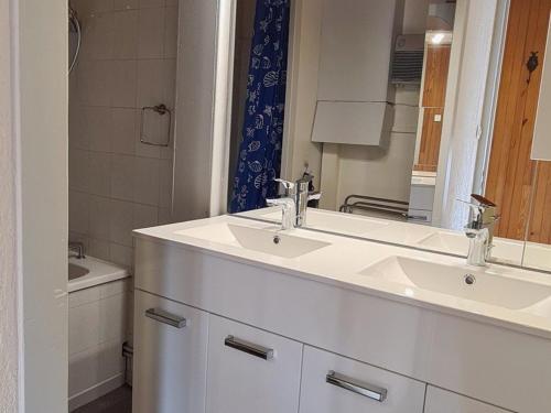 a white bathroom with two sinks and a mirror at Appartement Chamrousse, 4 pièces, 8 personnes - FR-1-340-232 in Chamrousse