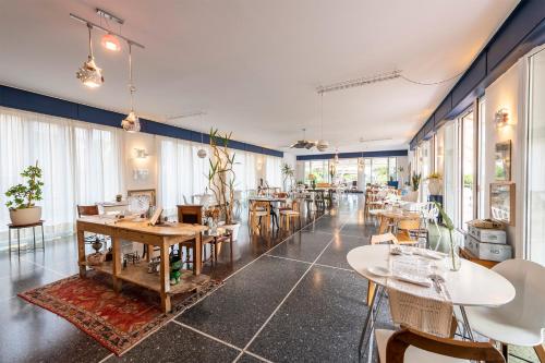 a restaurant with tables and chairs and windows at Hotel San Michele in Celle Ligure