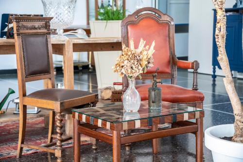 a table with a vase of flowers and a chair at Hotel San Michele in Celle Ligure