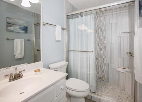 een witte badkamer met een toilet en een douche bij Phoenix V 1404 in Orange Beach