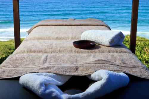 a bed with towels and a bowl on top of it at Massinga Beach in Massinga