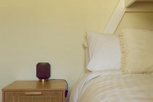 a bedroom with a bed and a lamp on a night stand at Little Belmont in Lunawanna