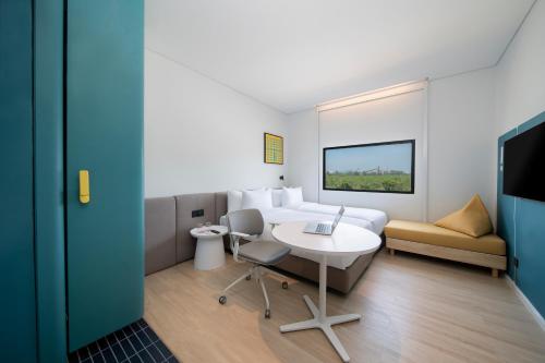a hotel room with a bed and a table and chair at GO Hotel Si Racha at Central Si Racha in Si Racha