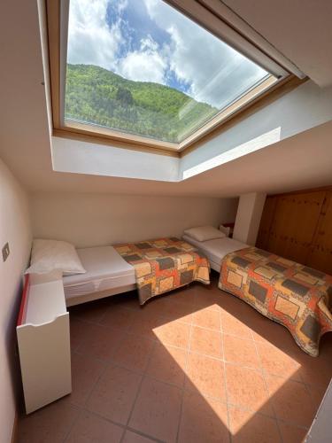 1 dormitorio con 2 camas y ventana grande en Villa AnRo en Vidiciatico