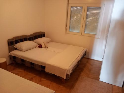 a bedroom with a bed with two pillows and a window at Luxury Apartment in Ulcinj