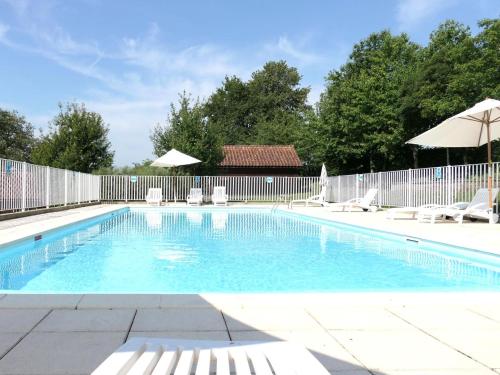 a swimming pool with chairs and a fence at Coquadou in Verneuil-sur-Vienne