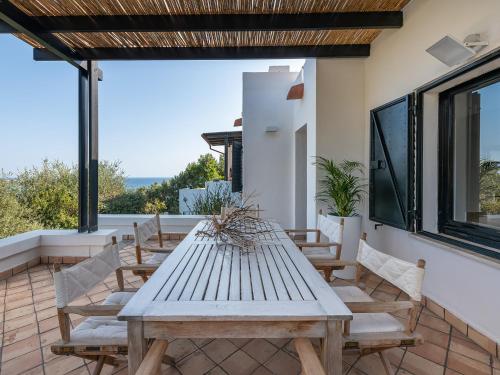 una mesa y sillas en un patio con vistas en Maison Raffaello - Exclusive villa with sea view, en Geremèas