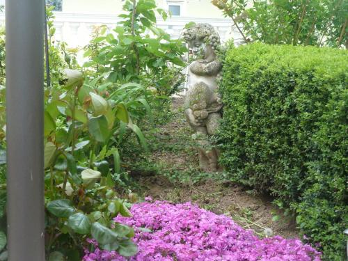 a statue in a garden with purple flowers at Hotel Schön in Aßmannshausen
