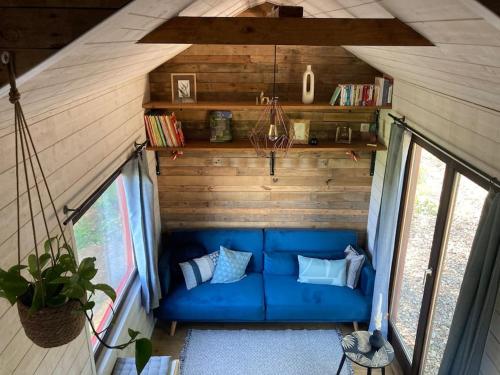 a blue couch in the middle of a room at Tiny Paradis in Vielsalm