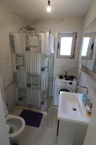 a bathroom with a sink and a washing machine at Apartment Sandrita in Kotor