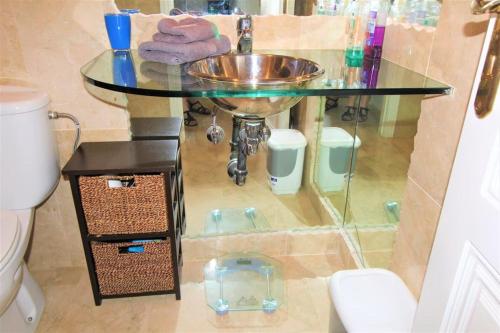 a bathroom with a sink and a glass counter at Fabulous 2 bed apartment on Las Ramblas Golf in Villacosta