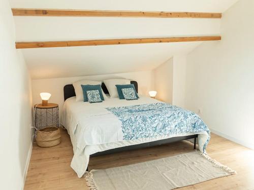 sypialnia z dużym łóżkiem z niebieskimi poduszkami w obiekcie Les Rives Bleues - atypique et climatisé - 2 salles d'eau - Wifi w mieście Albi