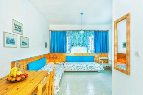 a bedroom with a bed and a table with a bowl of fruit at Xenios Faros Apartments in Possidi