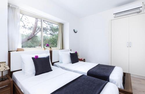 Duas camas num quarto com uma janela em Villa Ruyam em Marmaris