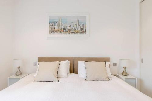 a bedroom with a white bed with two lamps at Lovely room in London