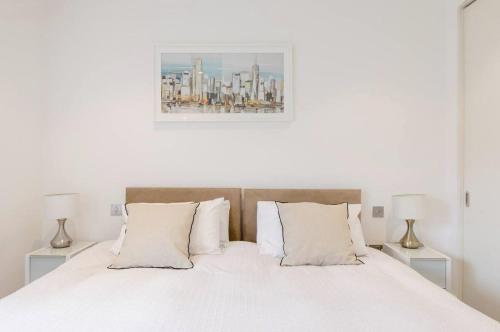 a bedroom with a white bed with two lamps at Home Stay - Coven Garden in London