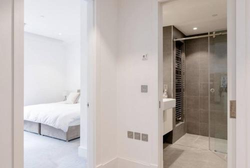 a bedroom with a bed and a bathroom with a shower at Home Stay - Coven Garden in London