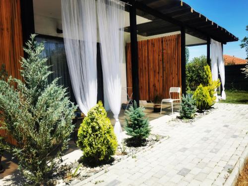 a patio with christmas trees and a white curtain at Blue Breeze in Sinemorets