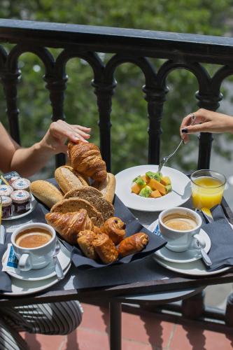 a table with a tray of breakfast foods and drinks at Gran Hotel Havana 4Sup by Escampa Hotels in Barcelona