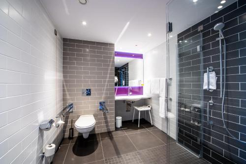 uma casa de banho com um WC, um lavatório e um chuveiro em Premier Inn Köln City Süd em Colônia