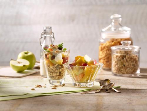 a table with a bowl of fruit and a jar of nuts at Premier Inn Köln City Süd in Cologne