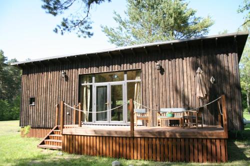 uma cabina de madeira com uma grande janela e um deque em Elulille maja mere läheduses Lahemaa rüpes em Andineeme