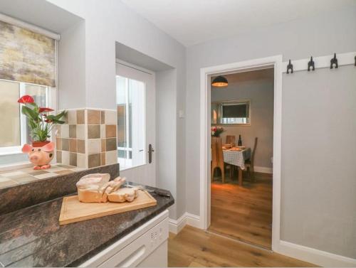 a kitchen with a cutting board on a counter at Sunshine Cottage Tideswell, Games room included. in Tideswell