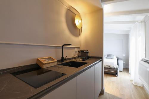 a kitchen with a sink and a bed in a room at PRESTIGE BOUTIQUE APARTHOTEL - Piazza Duomo View in Milan