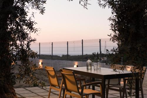una mesa y sillas con una mesa y una valla en Mela Luxury Apartments, en Maroulás