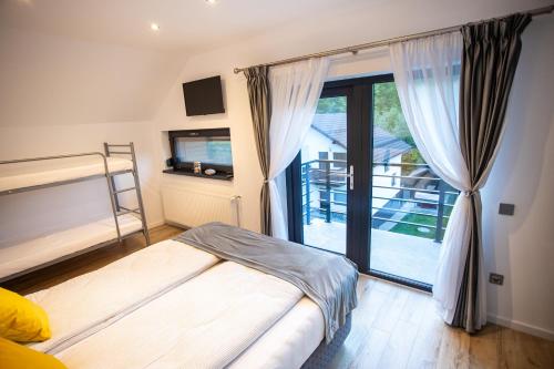 a bedroom with a bed and a sliding glass door at Cabana Armonia in Baia-Sprie