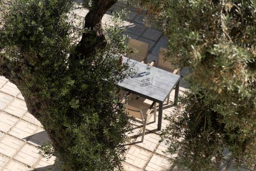 una vista aérea de una mesa y sillas junto a un árbol en Mela Luxury Apartments, en Maroulás