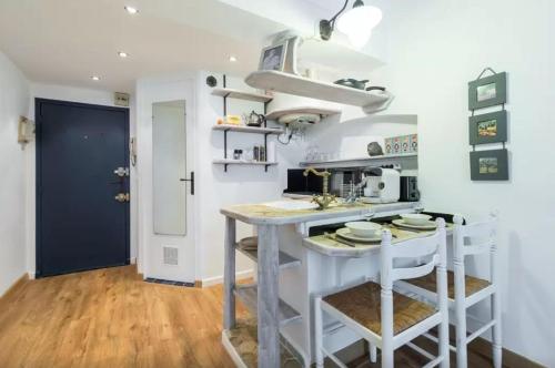 a kitchen with a counter and a table with stools at Le Fersen - cosy studio- coeur vieil Antibes in Antibes