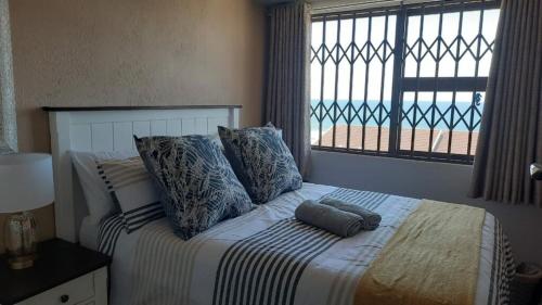 a bedroom with a bed with pillows and a window at Villa Siesta Flat No.6 in Margate