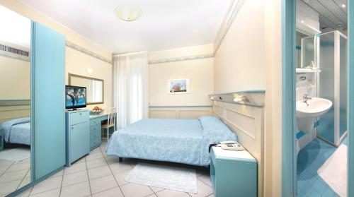 a hotel room with a bed and a sink and a bathroom at Hotel Arizona in Riccione