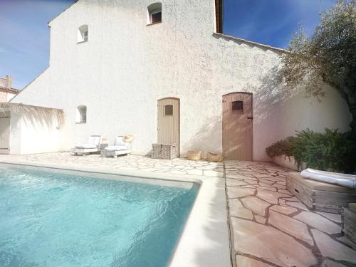 une maison avec piscine devant un immeuble dans l'établissement Blanc Sable Hôtel, au Golfe-Juan